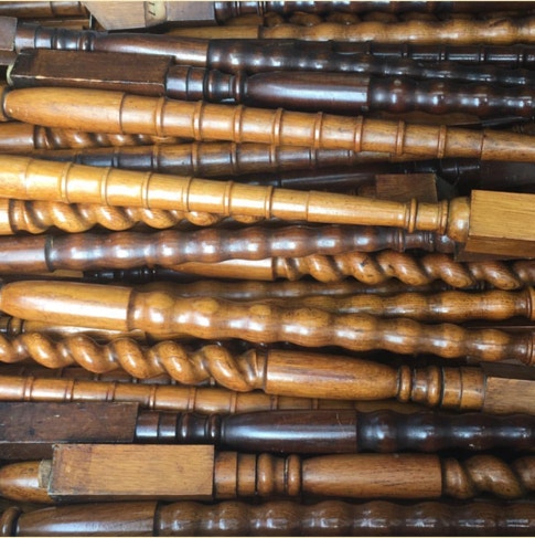 Stacked antique wood staircase balusters with turned and spiral profiles