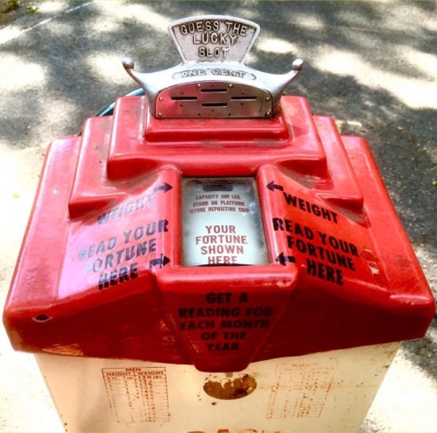 Top of a red penny fortune teller weighing machine reading Guess the Lucky Slot