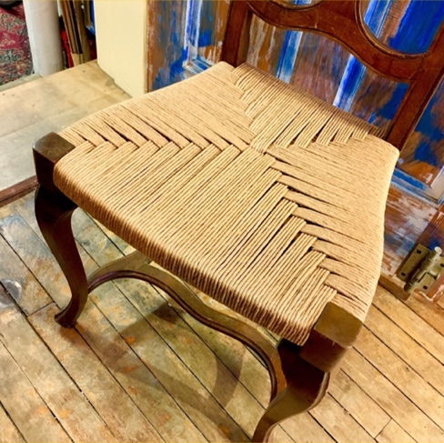 Freshly woven rush seat on an antique side chair in the workshop