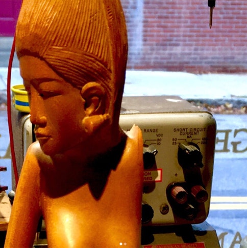 Hand-carved wooden figure of a woman on the bench after a clean arm break was reglued