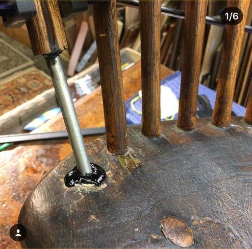 Adhesive being applied at a spindle mortise while rebuilding an antique chair back