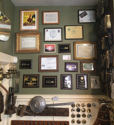 Workshop wall covered in framed awards, press features and certificates of recognition