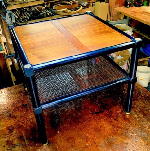 Refinished mid-century Baker side table with walnut top, black frame and caned lower shelf